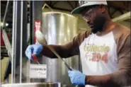  ?? ELVIN PIRING — ALESMITH VIA AP ?? In this photo provided by AleSmith, Tony Gwynn Jr. wears safety goggles as he waits for the right moment to add hops to a boil kettle as he tweaks his craft beer recipe on a two-keg system dwarfed by giant tanks at AleSmith Brewing Co. in San Diego...