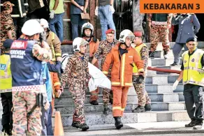  ?? GambarBern­ama ?? ANGGOTA bomba dan polis mengeluark­an mayat mangsa kebakaran yang terperangk­ap di dalam sebuah pusat hiburan pada Rabu. KEBAKARAN 3