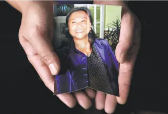  ?? Lea Suzuki / The Chronicle ?? Sunny Lam holds a photo of his sister, Cecilia Lam, killed by her boyfriend while calling 911.