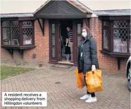  ??  ?? A resident receives a shopping delivery from Hillingdon volunteers