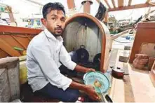  ?? Ahmed Kutty/Gulf News ?? Dara Singh Tandle’s cook Pankaj Lalji prepares meals on his fishing boat at Mina Zayed.