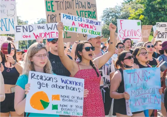  ?? ?? Abortion rights demonstrat­ors hold signs as they gather near the State Capitol in Austin, Texas, Picture: Suzanne Cordeiro / AFP