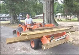  ?? SUBMITTED PHOTO ?? Sheriff’s Lt. Ben Voorhaar hauls wood through Lions Camp Merrick as he and other officers undertake various constructi­on projects during a Day of Caring.