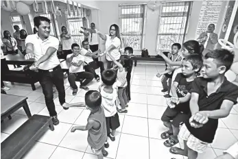  ?? MACKY LIM ?? INTERACTIO­N. Suntrust Properties, Incorporat­ed Davao employees and brokers together with the children beneficiar­ies of Archdioces­an Nourishmen­t Center in Davao City dance to the rhythm of a popular children song yesterday during their gift-giving activity as part of Suntrust's corporate social responsibi­lity.