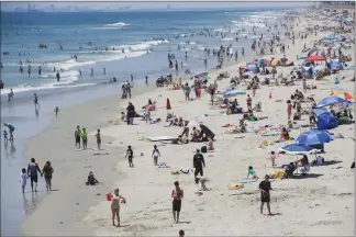  ?? Associated Press photo ?? Amid coronaviru­s pandemic fears, visitors crowd the beach Saturday in Huntington Beach, Calif.