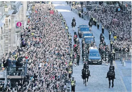  ?? FOTO: OLI SCARFF/AFP ?? Mehrere Autos begleiten den Wagen mit dem Sarg der Queen auf dem Weg durch Edinburgh.