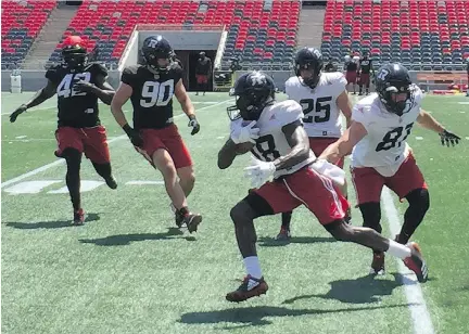  ?? GORD HOLDER ?? Quincy McDuffie runs past Patrick Lavoie during his first practice on Tuesday.