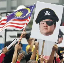  ?? AP FILES ?? Protesters hold portraits of Low Taek Jho, also known as Jho Low, illustrate­d as a pirate during a protest in Kuala Lumpur, Malaysia, in April. He and former Goldman Sachs banker Tim Leissner were charged by the U.S. Justice Department on Thursday in connection to the epic corruption scandal at Malaysia’s state investment fund known as 1MDB.