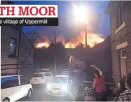  ??  ?? Residents watch as fires burn above village of Uppermill