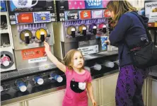 ?? Gabrielle Lurie / The Chronicle ?? Meira Rose Lesle, 4 ,and her mother, Alisa Dichter, get Slurpees at a 7-Eleven store on Mission Street in S.F.