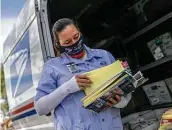  ?? John Moore / Getty Images ?? Postal Service carrier Dawnya Allred sorts mail, including mail-in ballots, for delivery in Phoenix.