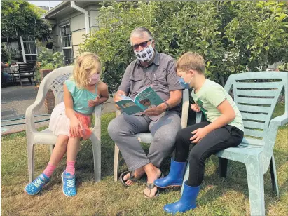  ?? HUMBOLDT LIBRARY FOUNDATION — SUBMITTED ?? Humboldt Library Foundation board member Peter LaVallee is pictured reading the book “I Know Germs” to two of his grandchild­ren.