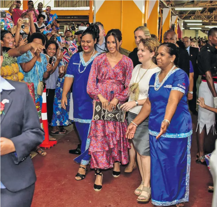  ?? Photo: DEPTFO News ?? The Duchess of Sussex Meghan Markle visits the Suva Market on October 24, 2018, with a figue ‘Frederica’ floral print maxi dress, a Castaner ‘Carina’ canvas wedge shoe and her Fijian-made pouch.