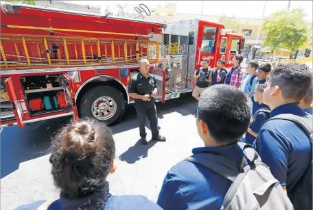  ?? Luis Sinco Los Angeles Times ?? LAFD CAPT. Eddie Marez talks with freshmen at the new firefighte­r-themed magnet program at Wilson High. “We’re trying to capture them at a young age to get them interested in a career and what they need to prepare for,” says Marez, who will teach at both magnets.