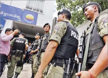  ?? PHA LINA ?? Heavily armed police wait in front of the CNRP headquarte­rs in Phnom Penh during a search for acting opposition leader Kem Sokha in May.