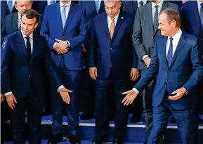  ??  ?? Where’s Theresa? Emmanuel Macron, left, and Donald Tusk joke yesterday that Mrs May is missing from the summit ‘family photo’