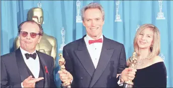  ?? — Afm photo ?? bastwood holds up his two oscars at the SRth Academy Awards, which he won for Best director and Best micture for ‘rnforgiven’ on March 29, 1993. he is flanked by presenters Jack Nicholson and Barbra streisand.