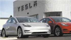  ?? David Zalubowski / Associated Press ?? Tesla has paused production of the Model 3, like these seen on a dealer’s lot near Denver, to make upgrades to its assembly line it hopes will boost output.