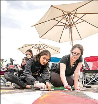  ?? NICK ELLIS / FOR THE CALIFORNIA­N / FILE ?? Medha Panchal, left, and Hannah Hurst work together on their art piece during last year’s Via Arte. The annual event, put on by the Bakersfiel­d Museum of Art, returns to The Marketplac­e this weekend with new guidelines in place to keep artists, attendees and BMoA staff safe.