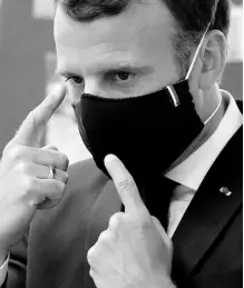  ?? AP ?? French President Emmanuel Macron wears a protective face mask as he speaks with schoolchil­dren at the Pierre Ronsard elementary school Tuesday in Poissy, outside Paris.