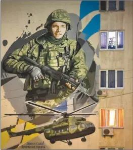  ?? ?? A mural depicts Andriy Ogorodnik, 23, a soldier of Ukraine’s Azov regiment, on an apartment building wall Feb. 2 in Kyiv. Ogorodnik was killed in a battle with Russian troops on April 26, 2022, while defending the Azovstal plant in Mariupol.