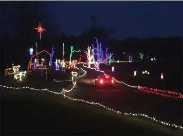  ?? BILL DEBUS — THE NEWS-HERALD ?? A car begins its journey through Bethlehem Hills Christmas Light Park on Dec. 28. The park, which is set up on the grounds of Berkshire Hills Golf Course in Chester Township, consists of 60displays and 3million computer-chipped LED lights, many of which are synchroniz­ed to music.