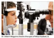  ?? AP ?? Dr. Albert Maguire checks the eyes of Misa Kaabali, 8. Misa was 4 years old when he received his gene therapy treatment for a genetic mutation. Patients with the condition generally start losing their sight before 18.