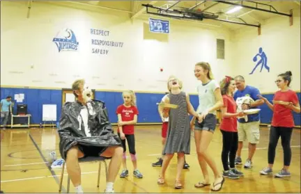  ?? BEN LAMBERT — HEARST CONNECTICU­T MEDIA ?? Torrington Middle School students and staff took part in a dodgeball tournament and pieing to raise funds for charity and the school debate team. Above, students laugh after giving Assistant Principal Charlie McSpiritt a pie in the face during the...