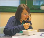  ??  ?? Teti talks on the phone about a patient’s condition as she has her lunch in her room of the infectious diseases department hosting the sub-intensive covid-19 unit.