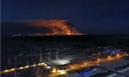  ?? Photograph: AP ?? A photo taken from the roof of the Chernobyl plant shows the forest fire burning on the horizon.
