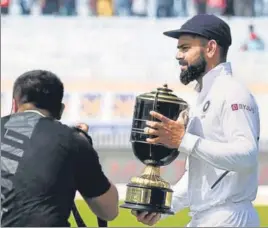  ?? AFP ?? ■
India captain Virat Kohli walks away with the winner’s trophy after the home team made a clean sweep of the three-Test series, in Ranchi on Tuesday.