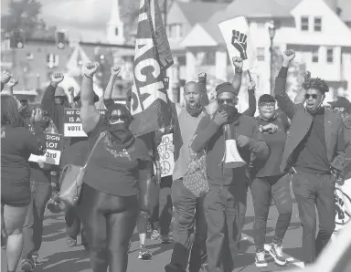  ?? BRAD HORRIGAN PHOTOS/HARTFORD COURANT ?? Dozens of people march on Albany Avenue on Saturday in a demonstrat­ion centered around racial injustice and Second Amendment rights for people of color.