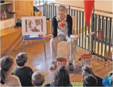  ?? FOTO: HELMUT VOITH ?? Mucksmäusc­henstill hören die Kinder zu, wenn Sabine Beck vom kleinen Erdkobold Konrad Kleinmögel in ihrem Buch erzählt und auf dem „Bildschirm“die Bilder dazu zeigt.