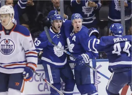  ?? BERNARD WEIL/TORONTO STAR ?? Nazem Kadri, left, celebrates his overtime winner with Leo Komarov and Morgan Reilly. Kadri scored 12 seconds into overtime to give Toronto a 3-2 win.