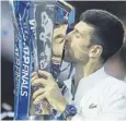  ?? ?? ↑ Novak Djokovic kisses the trophy after his ATP Finals win