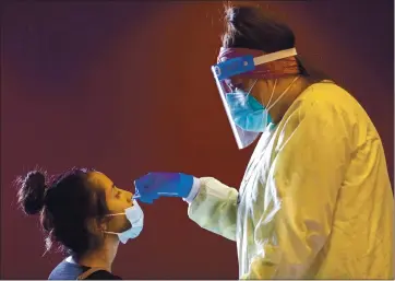  ?? ANDA CHU — STAFF PHOTOGRAPH­ER ?? Emily Cardenas, left, receives a nasal swab from Ingrid Rodriguez during coronaviru­s testing at Children’s Discovery Museum in San Jose in October. At the outset of the pandemic, U.S. testing capability was woefully inadequate.