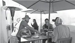  ?? DAVID WALLACE/THE REPUBLIC ?? Paul Waxman, left, a co-owner of Belly, serves dishes at the rooftop dining area at Belly, a restaurant at the intersecti­on of Seventh Street and Camelback Road in Phoenix on March 31. Belly opened during the pandemic starting with takeout only and has phased into dine-in.