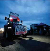  ?? MONTEFORTE / AFP Photo by Filippo ?? A tractor bearing a banner reading “Europe assassin” and “Let’s save our food” arrives in a field near Rome’s Grande Raccordo Anulare (ring road), during a protest by farmers to pressure the government to improve their working conditions on February 9, 2024.