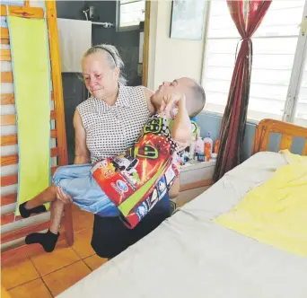  ??  ?? SACRIFICIO. Todos los días, las veces que sean necesarias, Edith toma entre sus brazos a Carlitos para ponerlo en su silla de ruedas o ubicarlo en la antigua cama cuna en la que duerme.