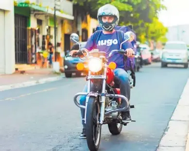  ??  ?? Uno de los motociclis­tas, popularmen­te llamados como “hugos”, mientras deja un pedido.