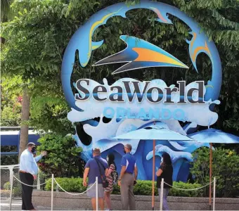  ?? TNS FILE ?? WELCOME BACK: SeaWorld Orlando president Kyle Miller, left, talks to invited guests before the park’s reopening.