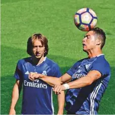  ?? AFP ?? Real Madrid’s Cristiano Ronaldo heads the ball as Luka Modric watches during a training session yesterday.