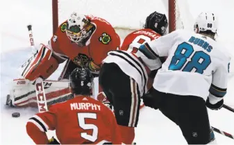  ?? Nam Y. Huh / Associated Press ?? Blackhawks goalie Jean-Francois Berube makes one of his 42 saves, turning away a shot by Sharks defenseman Brent Burns. Berube got the win in his first start with Chicago.