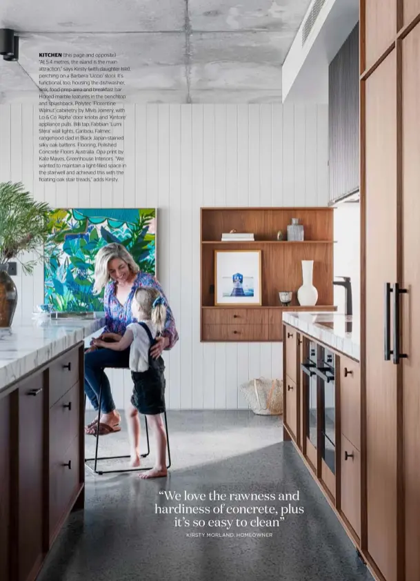  ??  ?? KITCHEN (this page and opposite)
“At 5.4 metres, the island is the main attraction,” says Kirsty (with daughter Isla), perching on a Barbera ‘Uccio’ stool. It’s functional, too, housing the dishwasher, sink, food-prep area and breakfast bar. Honed marble features in the benchtop and splashback. Polytec ‘Florentine Walnut’ cabinetry by Mivis Joinery, with Lo & Co ‘Alpha’ door knobs and ‘Kintore’ appliance pulls. Billi tap. Fabbian ‘Lumi Sfera’ wall lights, Caribou. Falmec rangehood clad in Black Japan-stained silky oak battens. Flooring, Polished Concrete Floors Australia. Opa print by Kate Mayes, Greenhouse Interiors. “We wanted to maintain a light-filled space in the stairwell and achieved this with the floating oak stair treads,” adds Kirsty.