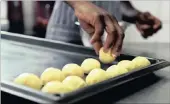  ??  ?? Simon, chef de partie, makes small cheese bread rolls.