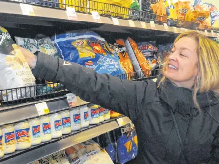  ?? JOE GIBBONS/THE TELEGRAM ?? Jackie Hyde of St. John's stocks up on storm chips Wednesday in a local supermarke­t in anticipati­on of the snowstorm forecast for Friday.