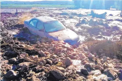  ?? JOHN LARSON/EL DEFENSOR CHIEFTAIN ?? Mud completely surrounds a car owned by Pat Zamora on Tarryall Farm Road after storms caused flooding in San Antonio on Sunday night.