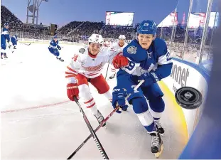  ?? FRANK GUNN/THE CANADIAN PRESS VIA AP ?? Toronto’s William Nylander, right, and Detroit’s Gustav Nyquist (14) chase the puck Sunday during the Centennial Classic at BMO Field, an outdoor venue in Toronto.