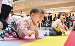  ??  ?? YOKOHAMA: Babies compete in a baby crawling competitio­n hosted by a Japanese magazine that specialize­s in pregnancy, childbirth and child-rearing, in Yokohama, Kanagawa prefecture yesterday. — AFP