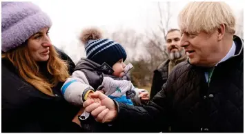  ?? ?? Put it there: Mr Johnson shakes hands with President Zelensky, above, who invited him to Ukraine. Boris also greeted parents and children, left, and spent time posing for selfies, right, during a visit to a church in Bucha